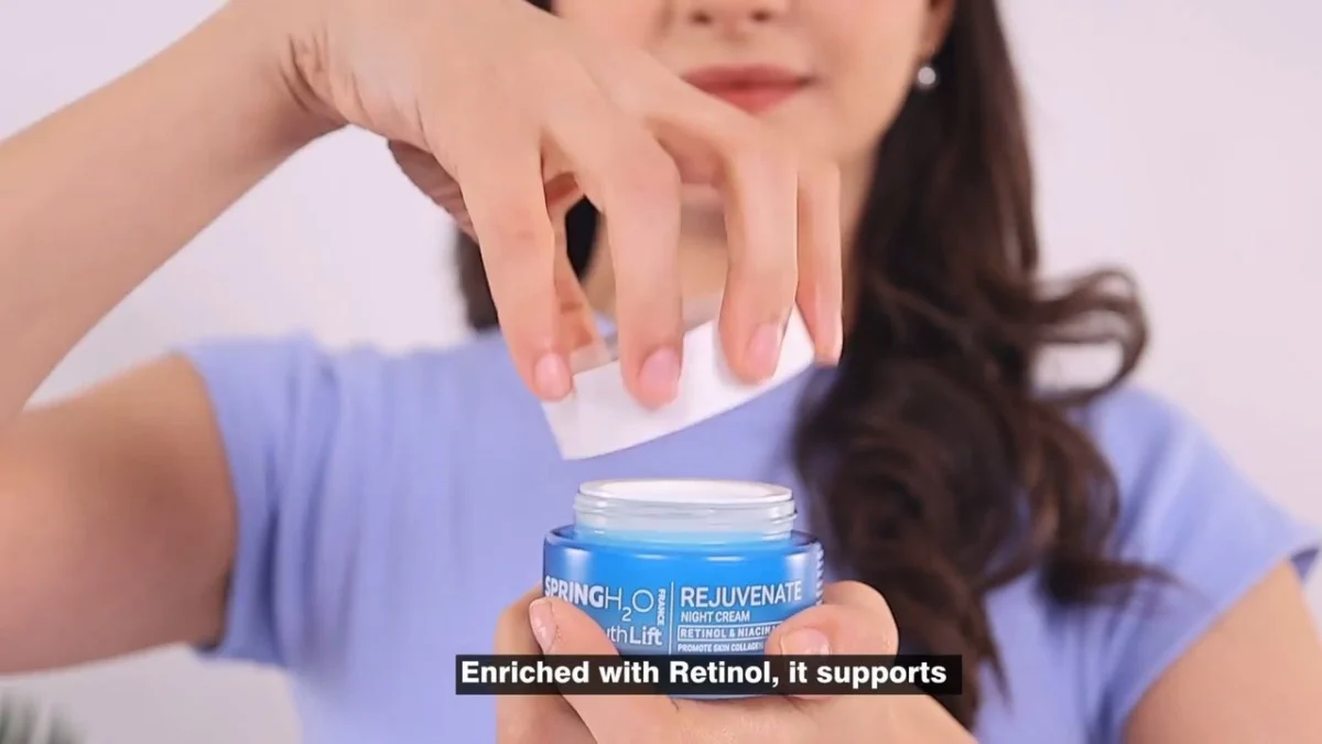 Close-up of hands lifting the lid of a blue night cream jar in a skincare product video, with an ingredient line shown as a caption, illustrating why a product name pronunciation guide matters