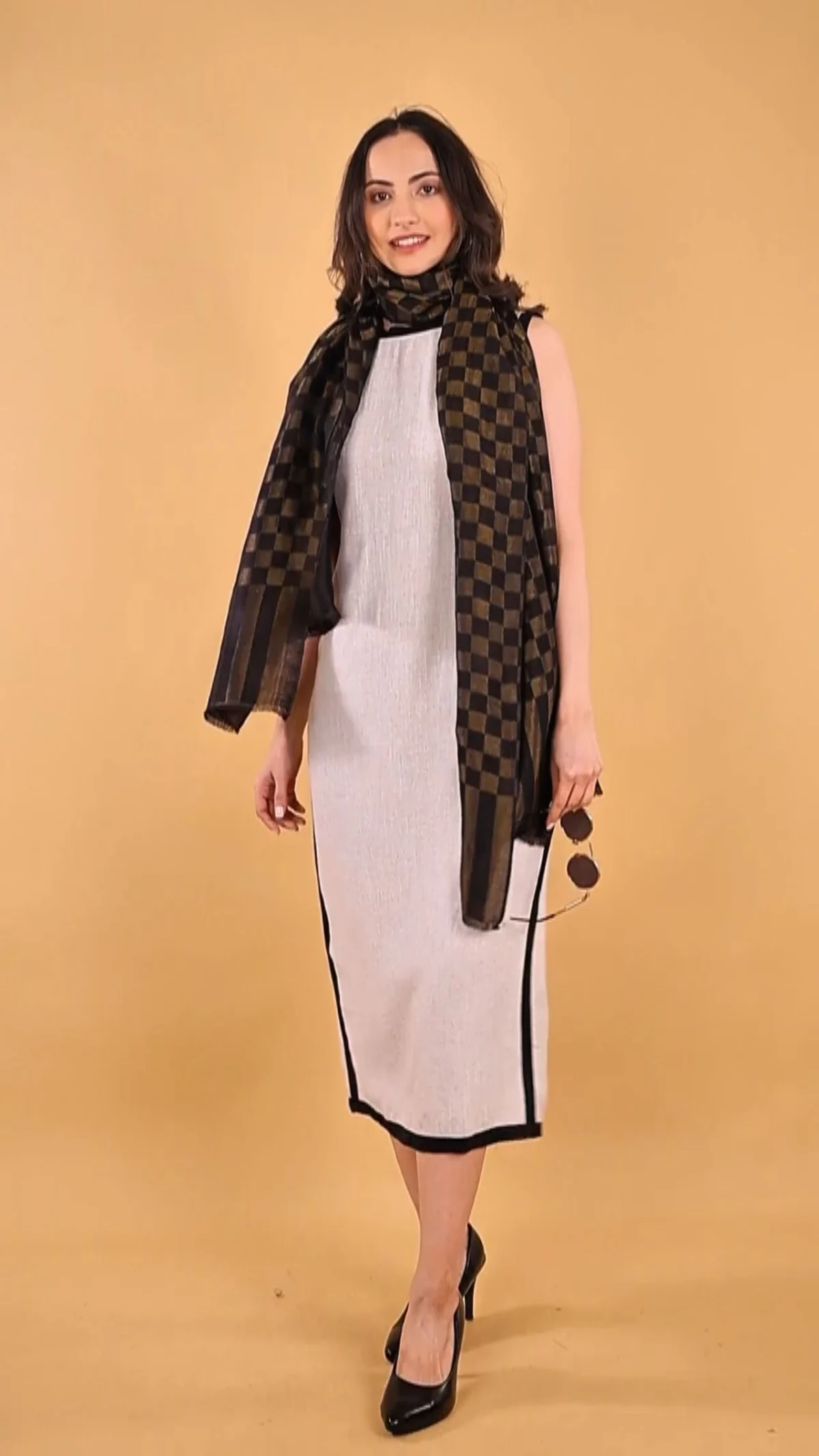 Full-length studio photograph of an adult woman wearing a light dress and dark patterned stole, a visual reference for the model casting checklist