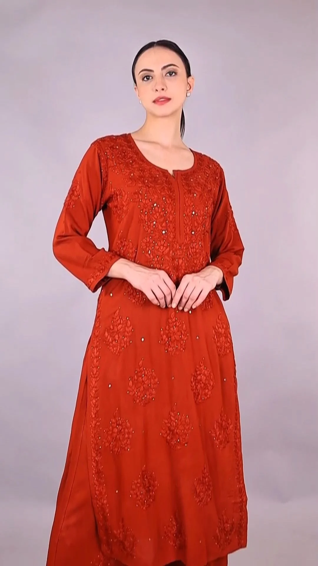 Indian woman model in a rust red embroidered straight kurta standing front-facing on a white studio background with headroom for vertical crops in a catalogue shoot planning setup