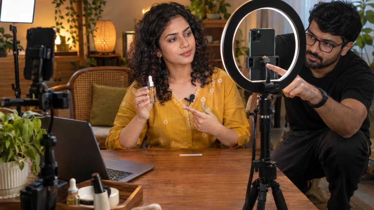 Behind the scenes: an Indian director adjusts the vertical phone framing on a tripod while a creator holds an unbranded serum bottle at chest height for a 9:16 ad creative under a ring light